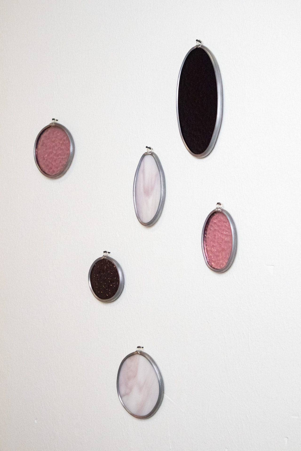 Zes ovale glas-in-lood muurhangers in roze en wit gemarmerd glas
