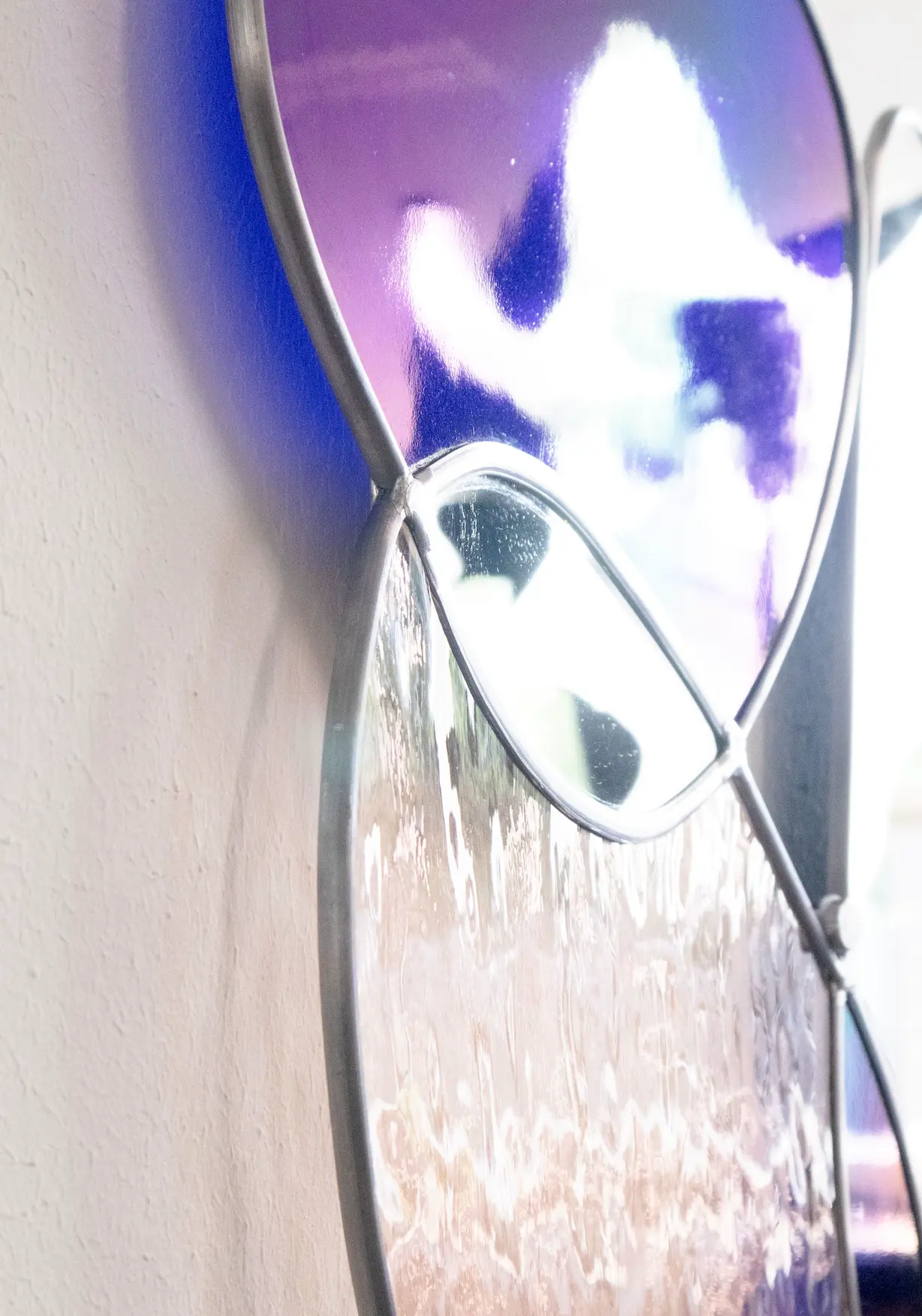 Detail van de glas-in-lood wanddecoratie met paars en spiegelglas